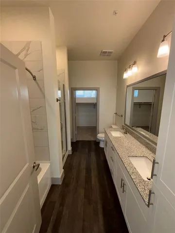 a bathroom with a granite countertop sink a mirror and a bathtub