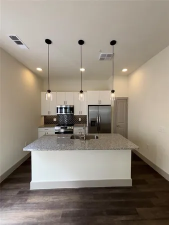 a large kitchen with kitchen island a counter top a stove and wooden floor