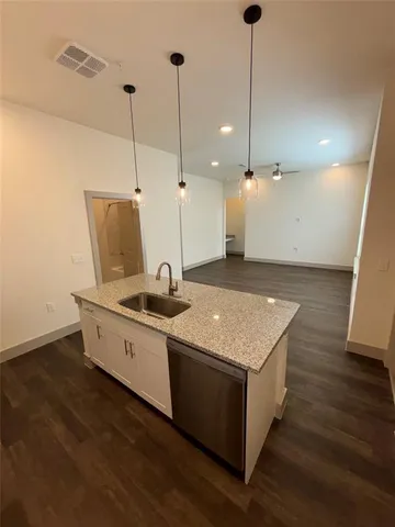 a kitchen with a stove and a wooden floor
