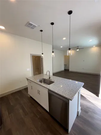 a kitchen with a sink stove and wooden floor