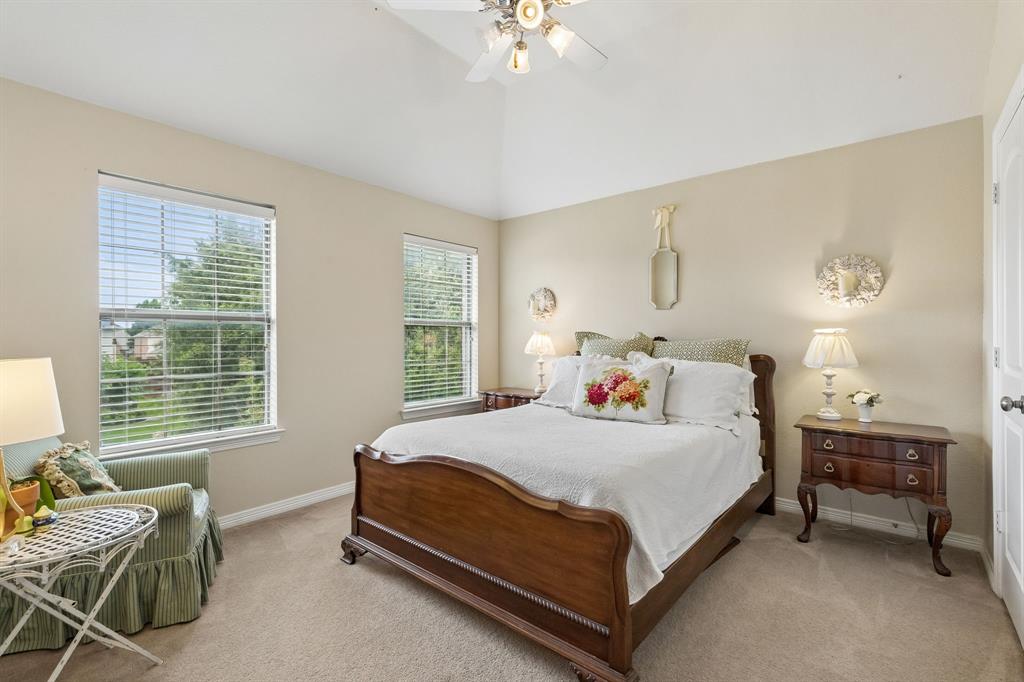 960 Remuda Road Frisco, TX 75033 - Photo 27 of 39 Bedroom featuring a vaulted ceiling with a ceiling fan, two windows with blinds, a wood-finish bed frame, and carpet flooring