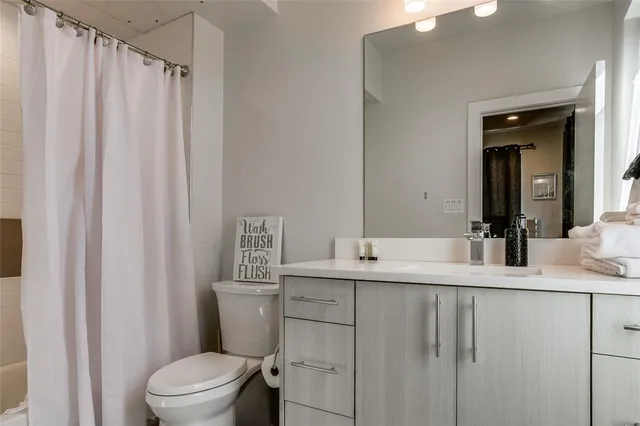 a bathroom with a granite countertop sink toilet and a mirror