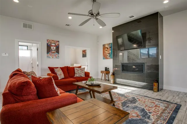 a living room with furniture kitchen view and a wooden floor