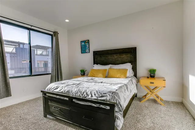 a bedroom with a large bed chandelier and a window