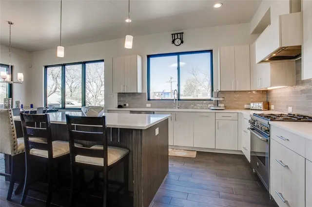 a kitchen with a stove a sink a dining table and chairs