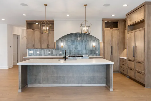 a view of a kitchen with kitchen island a sink stainless steel appliances and cabinets