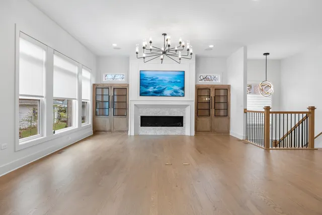 wooden floor fireplace and windows in an empty room