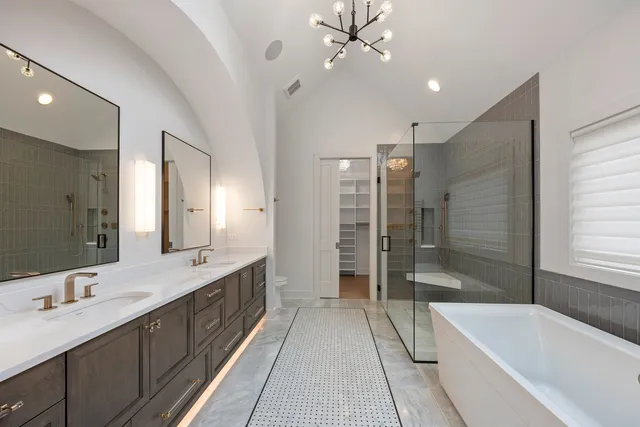 a bathroom with a tub a sink shower and a mirror