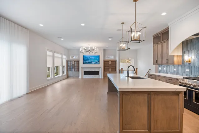 a large kitchen with stainless steel appliances a large counter top a sink a stove and a refrigerator