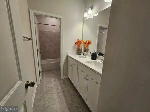a bathroom with a double vanity sink toilet and shower