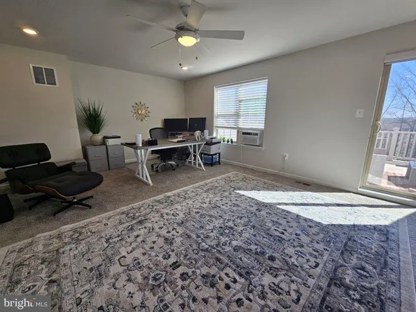 a living room with furniture a rug and a window