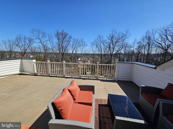a balcony with wooden floor and outdoor seating
