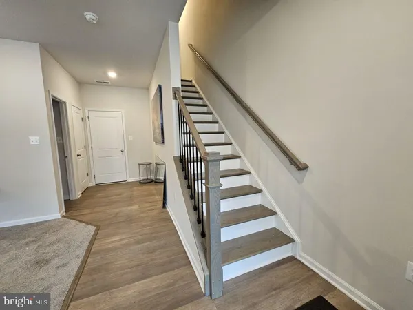 a view of a hallway with wooden floor and entryway