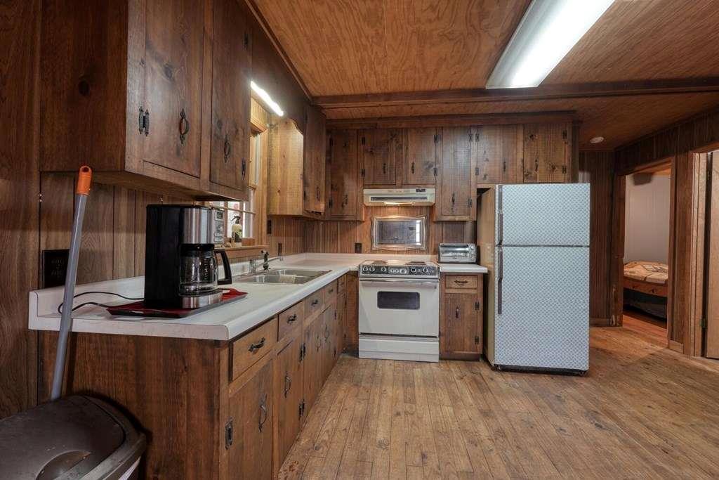 2479 Plum Orchard Road Clayton, GA 30525 - Photo 34 of 72 a kitchen with a refrigerator a stove a sink dishwasher and wooden cabinets with wooden floor