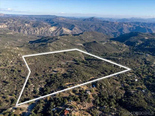 a view of a dry yard with mountains in the background
