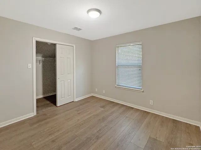 an empty room with a chandelier fan