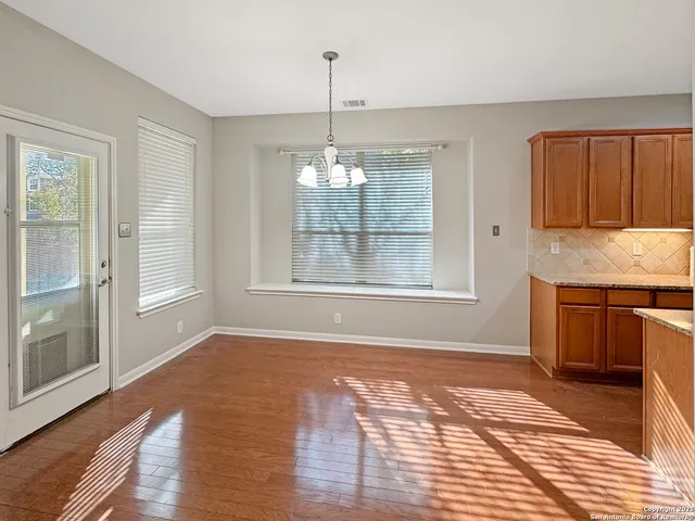 a view of a hallway with wooden floor and stairs