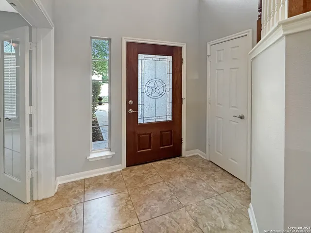 a view of an empty room with wooden floor fireplace and a window