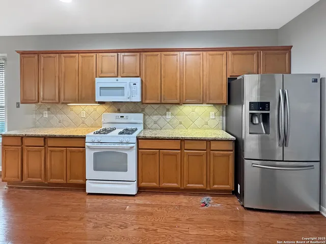 a view of a livingroom with wooden floor a fireplace and window
