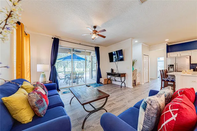 a living room with furniture two window and a flat screen tv