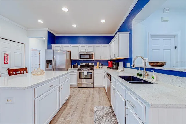 a kitchen with kitchen island granite countertop a sink and white appliances