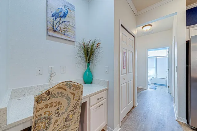 a hallway with painting on the wall and a potted plant