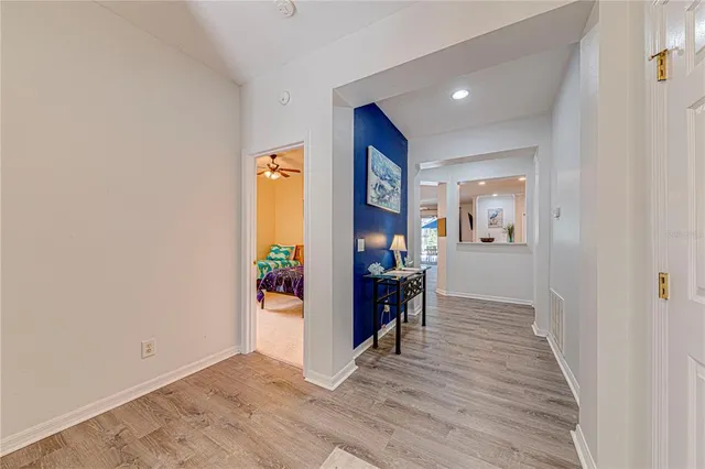 a view of a hallway with wooden floor and a living room