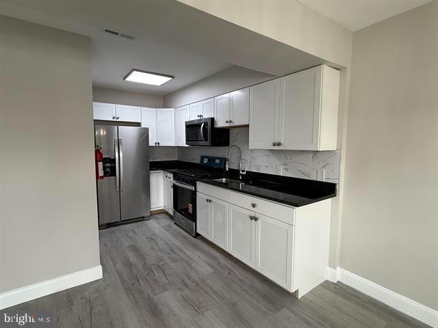 1964 East Oak Road, Unit G2 Vineland, NJ 08361 - Photo 3 of 28 a kitchen with granite countertop a refrigerator and a stove top oven