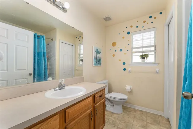 a bathroom with a granite countertop sink a toilet and a mirror