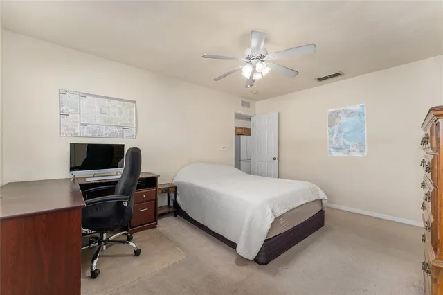 a bed room with a bed and a ceiling fan