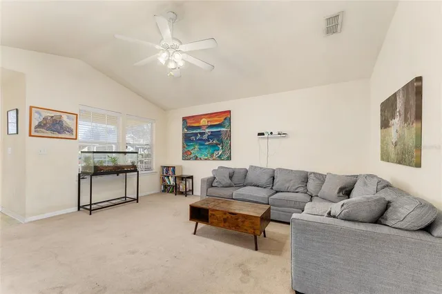 a living room with furniture and a ceiling fan