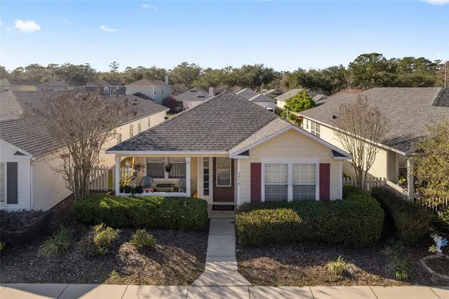 a view of a big house with a big yard plants and large trees