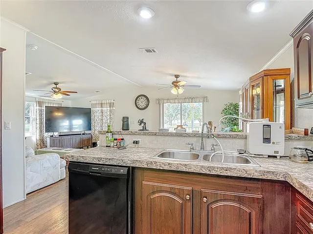 a kitchen with stainless steel appliances granite countertop a refrigerator a stove and a sink with wooden floor