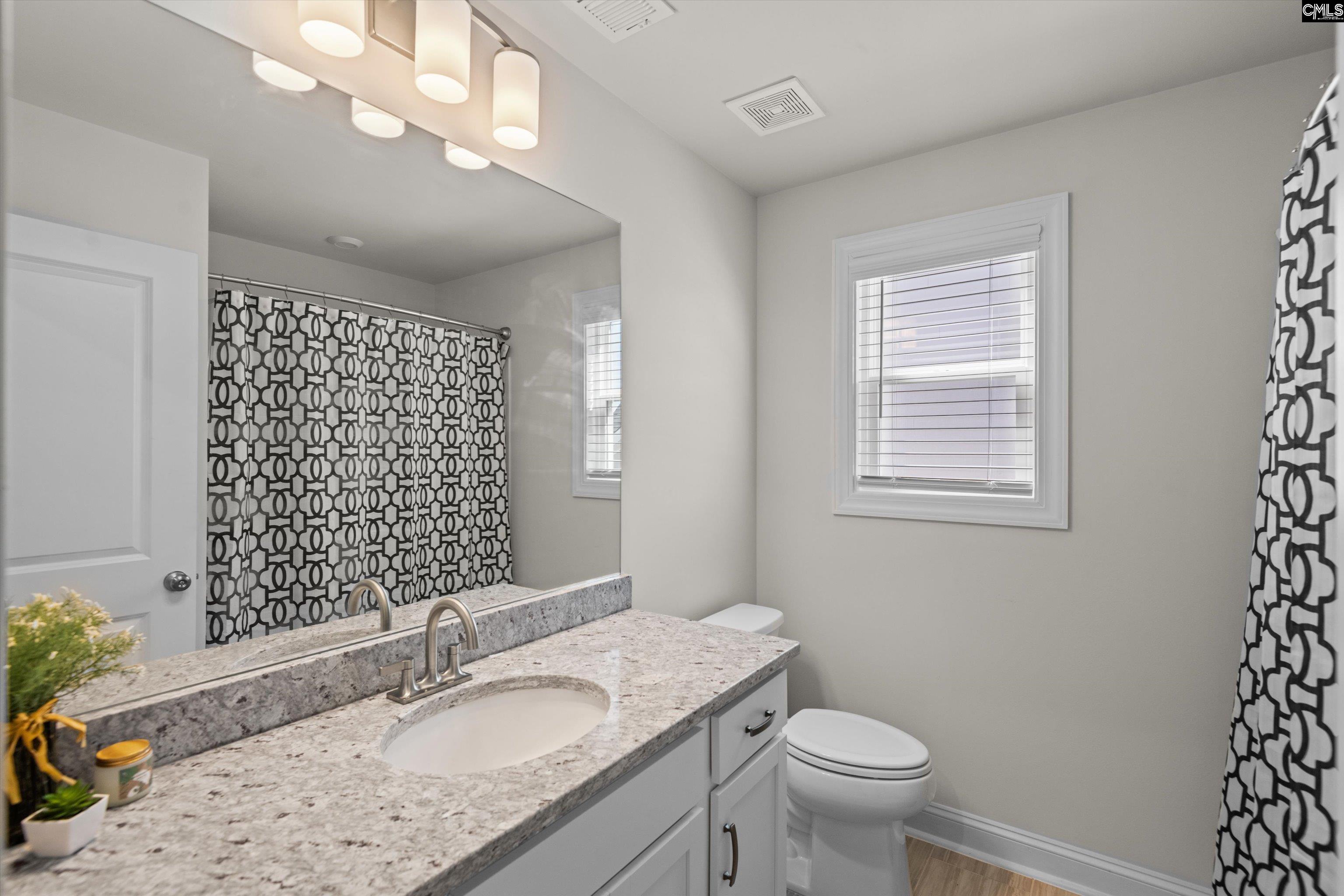 558 Wild Ginger Loop Irmo, SC 29063 - Photo 34 of 42 a bathroom with a granite countertop double vanity sink mirror and toilet
