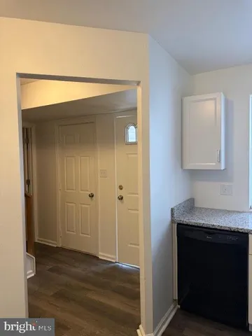 a view of hallway with wooden floor and cabinet