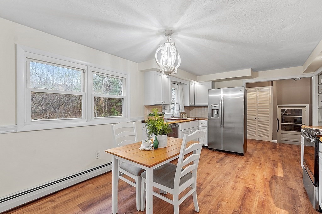 663 Sterling Road Lancaster, MA 01523 - Photo 15 of 33 a kitchen with stainless steel appliances a dining table chairs and chandelier