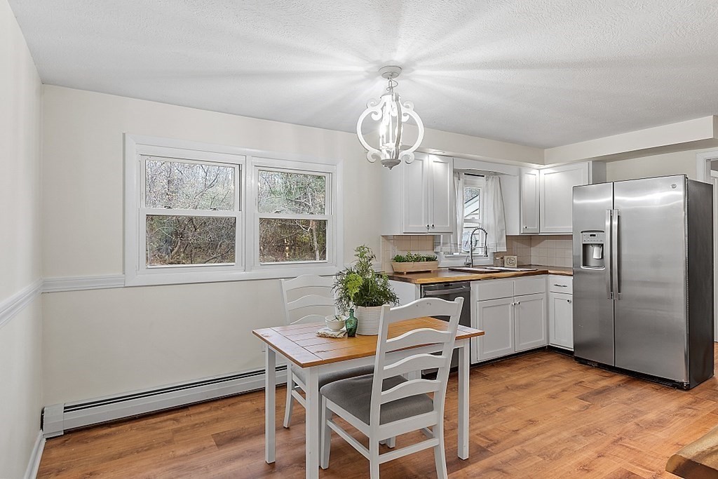 663 Sterling Road Lancaster, MA 01523 - Photo 16 of 33 a kitchen with stainless steel appliances granite countertop a dining table chairs and chandelier