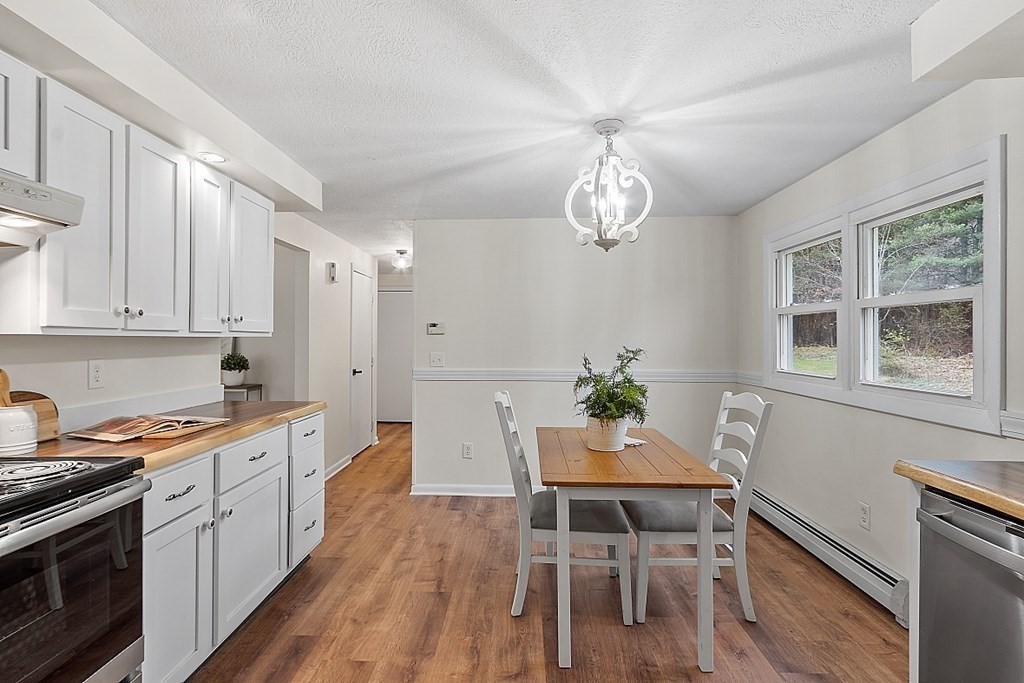 663 Sterling Road Lancaster, MA 01523 - Photo 17 of 33 a kitchen with a dining table chairs stainless steel appliances and cabinets