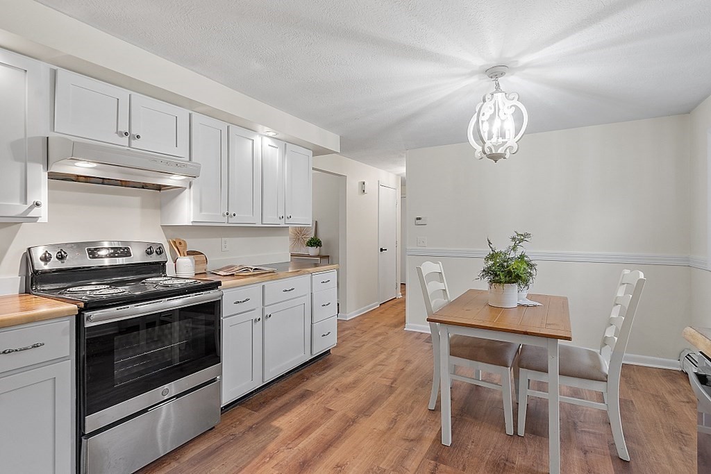 663 Sterling Road Lancaster, MA 01523 - Photo 18 of 33 a kitchen with stainless steel appliances a white table and chairs in it