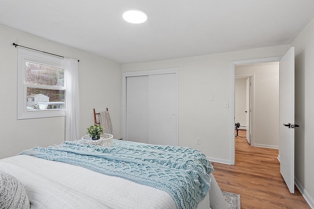 663 Sterling Road Lancaster, MA 01523 - Photo 24 of 33 a bedroom with a bed and wooden floor
