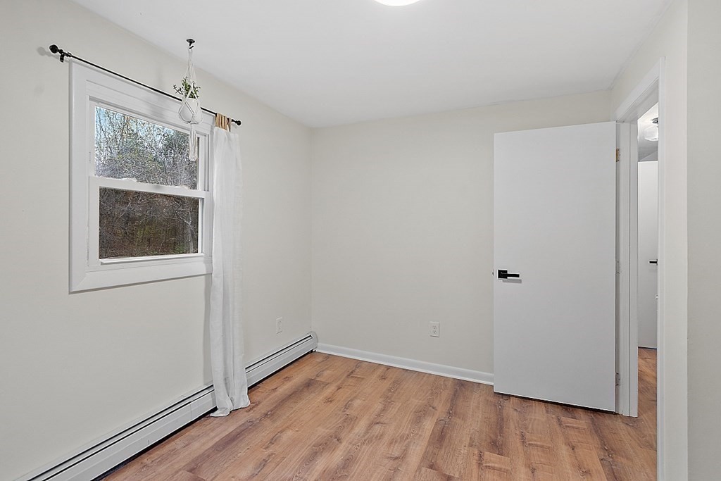 663 Sterling Road Lancaster, MA 01523 - Photo 29 of 33 a view of an empty room with wooden floor and a window