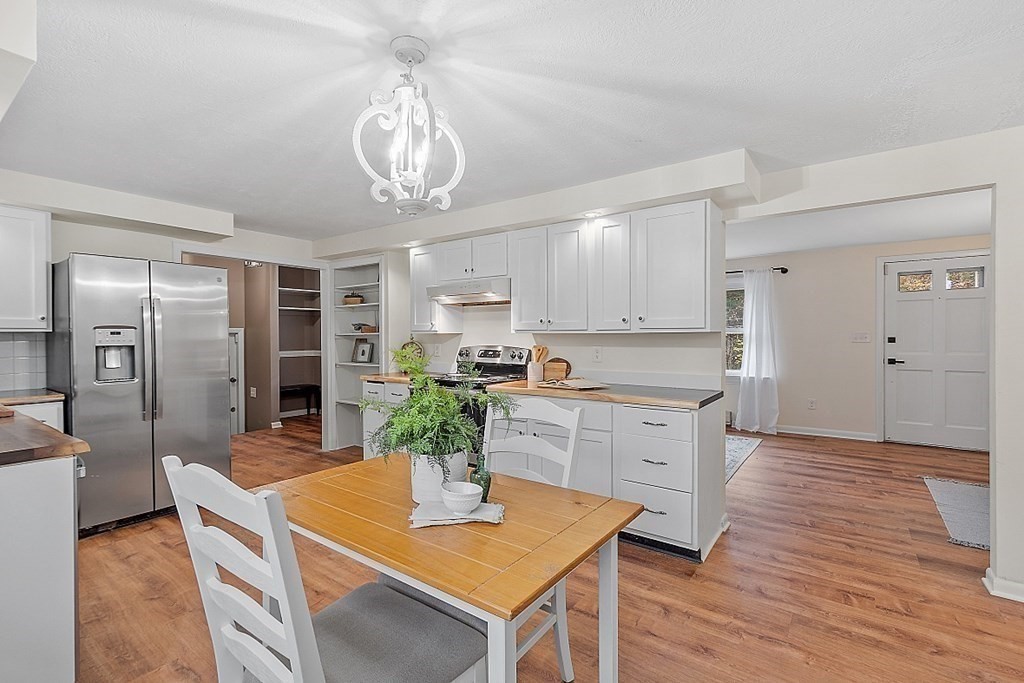 663 Sterling Road Lancaster, MA 01523 - Photo 3 of 33 a kitchen with stainless steel appliances granite countertop a refrigerator a stove a sink dishwasher and white cabinets with wooden floor