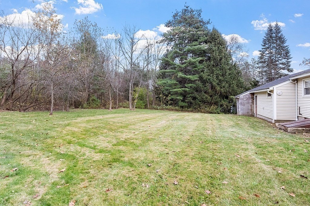 663 Sterling Road Lancaster, MA 01523 - Photo 32 of 33 a backyard of a house with lots of green space