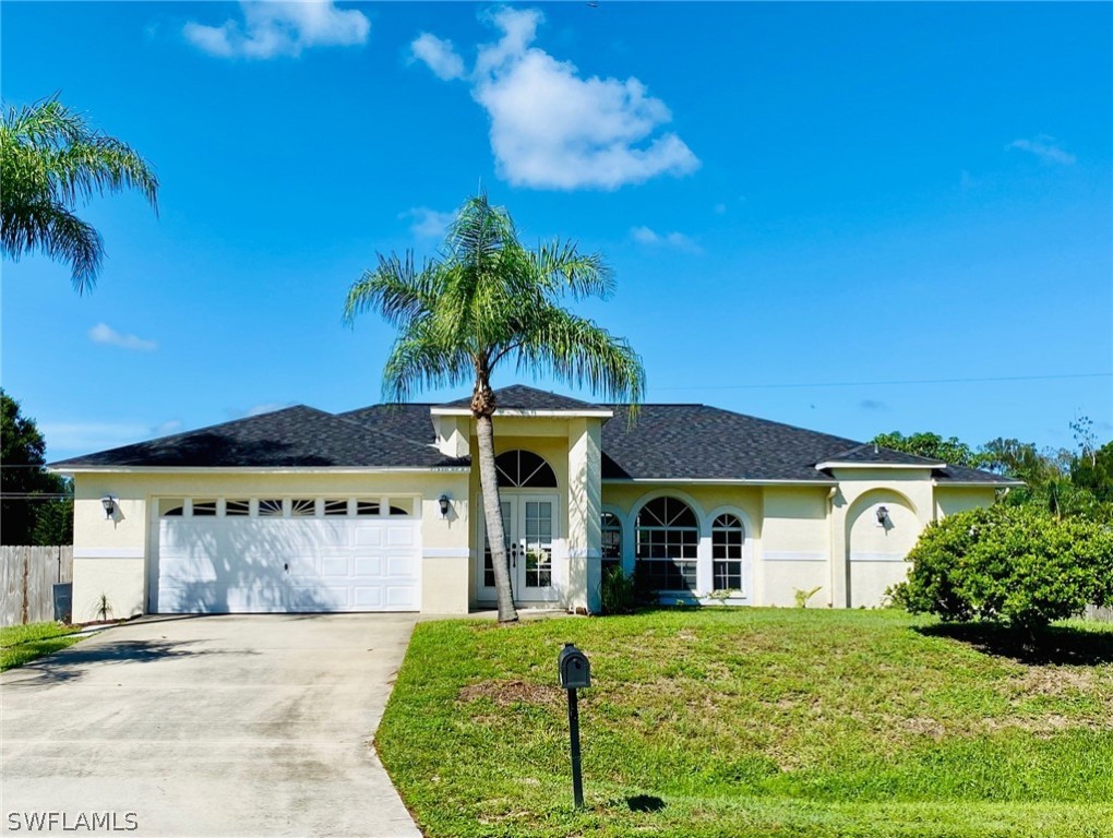 a front view of a house with a garden and yard