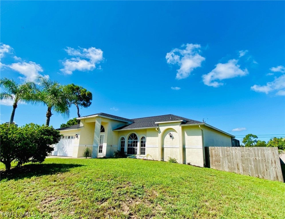 18566 Violet Road Fort Myers, FL 33967 - Photo 2 of 30 a view of a house with a big yard and large trees