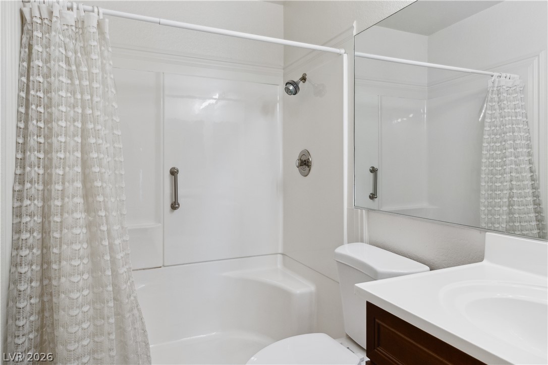 2146 High Dunes Lane Laughlin, NV 89029 - Photo 26 of 64 Primary Bathroom featuring a shower with shower curtain, vanity, and toilet