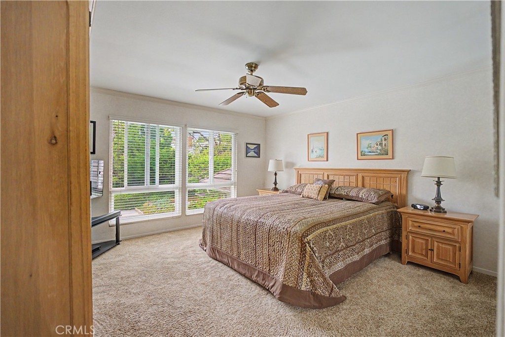 22671 Town Crier Road Calabasas, CA 91302 - Photo 29 of 35 a spacious bedroom with a bed and a chandelier