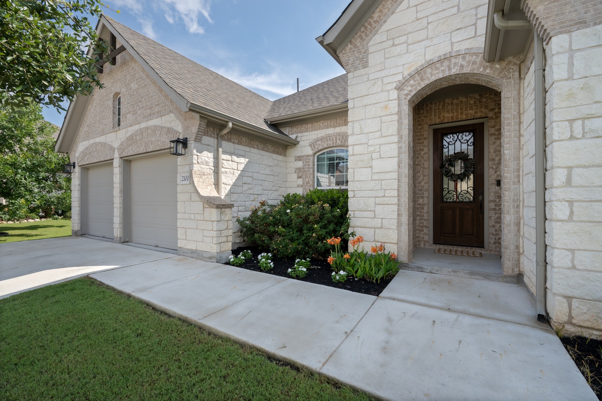 2100 Highland Ridge Road Georgetown, TX 78628 - Photo 4 of 30 Elegant brick and stone facade welcomes with an arched entry and landscaped garden beds.