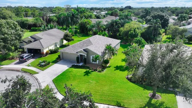 an aerial view of a house with yard and green space