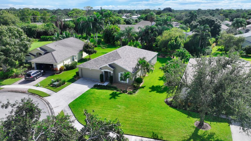 an aerial view of a house with yard and green space
